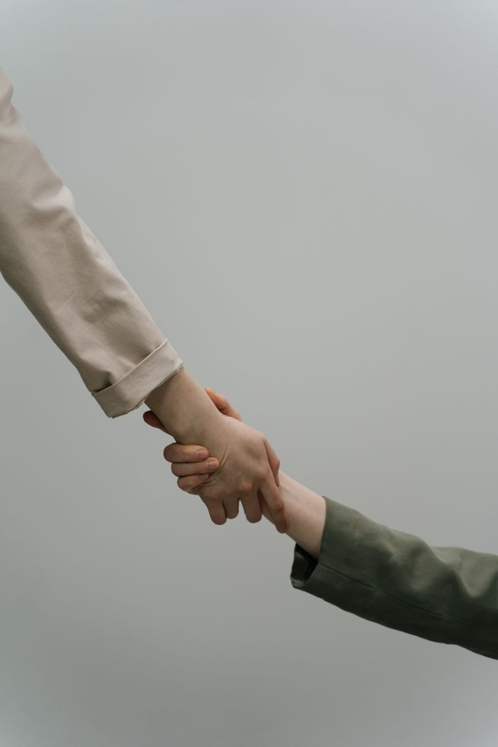 Mastering the First Impression: Your intriguing post title goes here A close-up view of two people shaking hands, symbolizing cooperation and unity, with neutral-toned sleeves.